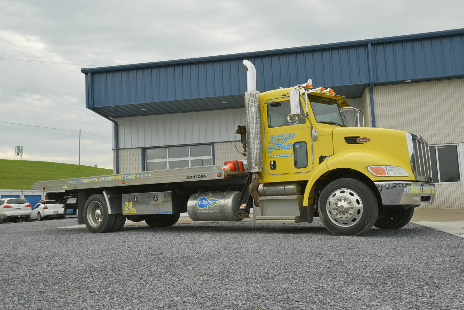 Side of Yellow flatbed truck for Baker's Body Center