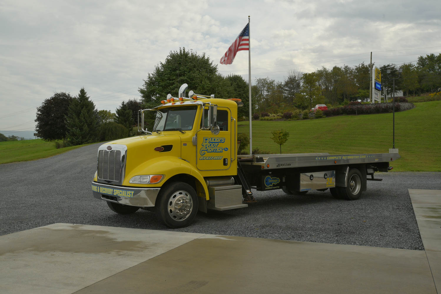 Yellow flatbed truck for Baker's Body Center